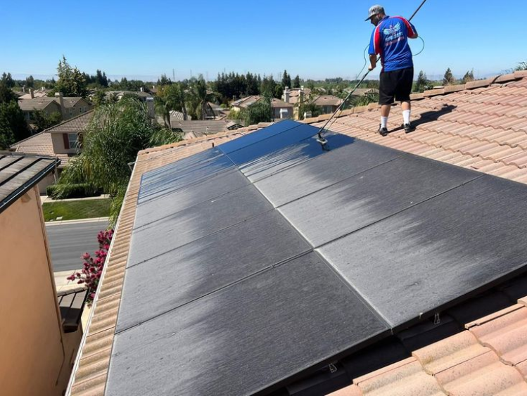 Solar panel cleaning on residential rooftop using professional brush system