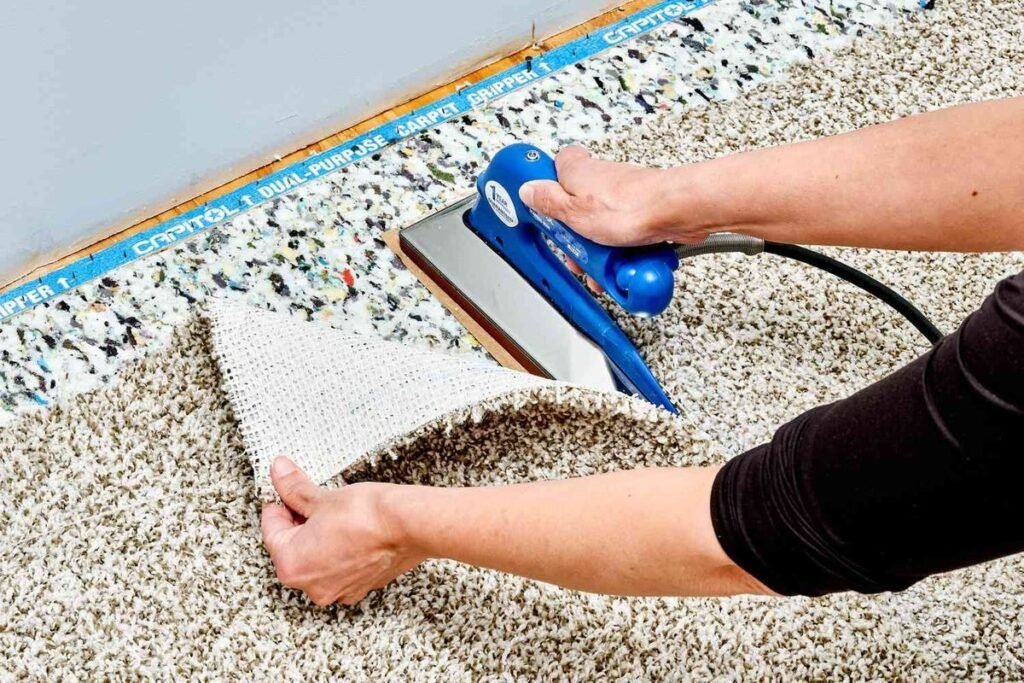 Technician using carpet seam iron to repair and join carpet edges during professional carpet installation.