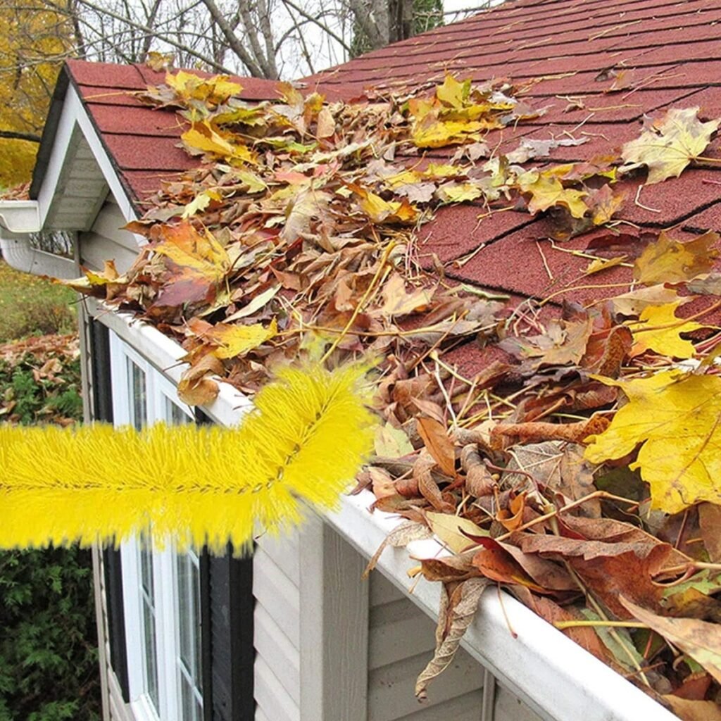 Brush, removing leaves and debris from clogged house gutters on residential roofs.