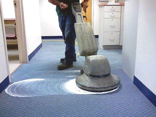 Professional carpet cleaning using rotary machine in office space
