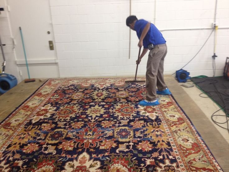 Technician deep cleaning large rug using scrubbing machine in Melbourne rug cleaning facility