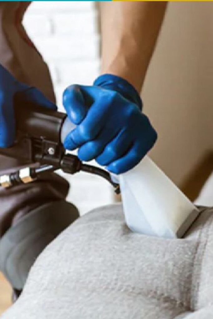 Close-up upholstery cleaning using extraction tool removing dirt from fabric sofa