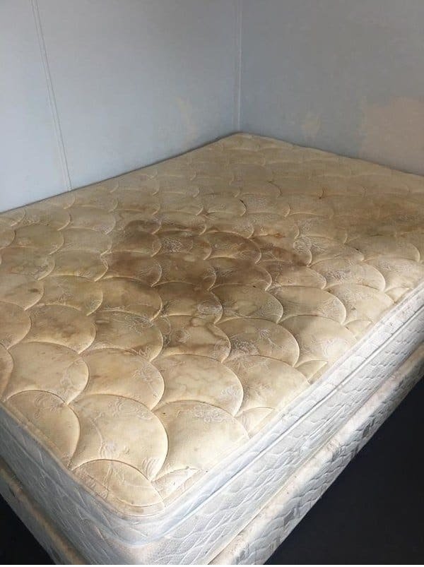 Heavily stained mattress with visible dirt, discolouration, and embedded grime requiring professional deep mattress cleaning and sanitisation.