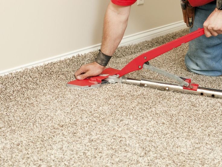 Professional technician using a power stretcher to perform Carpet Re Stretching Melbourne, removing wrinkles, ripples, and loose carpet for a smooth, secure, and long-lasting finish.
