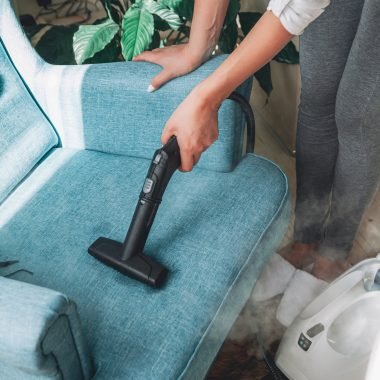 Hand cleaning a armchair with steam cleaner, Home cleaning conce